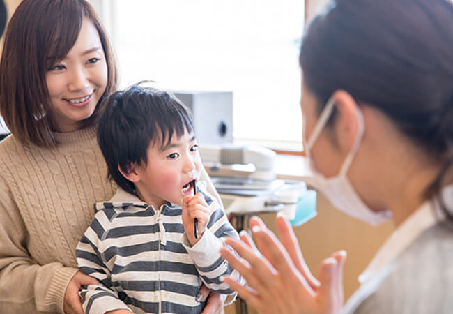 スタッフが子供に歯磨きを教えている様子